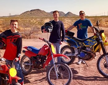 Henry and his two sons out in the desert with dirt bikes.