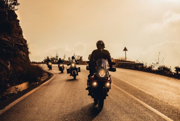 Group of Motorbikers Riding on Motorcycles along Mountainous Road in Mild Sunset Light. Extreme Sport. Active Life.