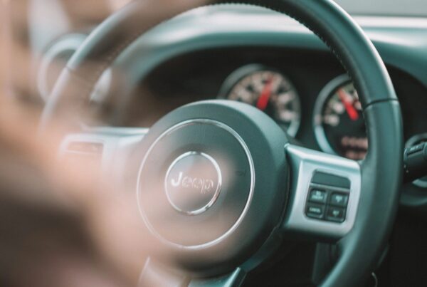 Jeep steering wheel with the car dashboard in the background. Driver's seat point of view.